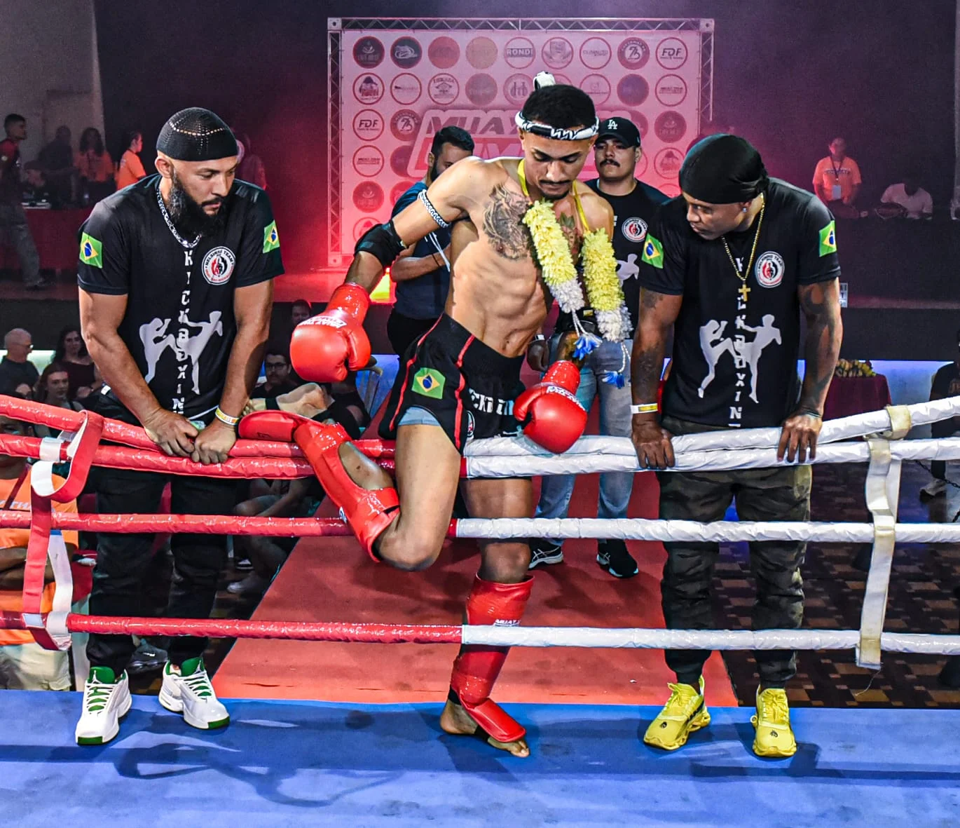Atleta da NT Fight com guirlanda tailandesa entrando no ringue acompanhado pelo Prof. Nélsinho no corner