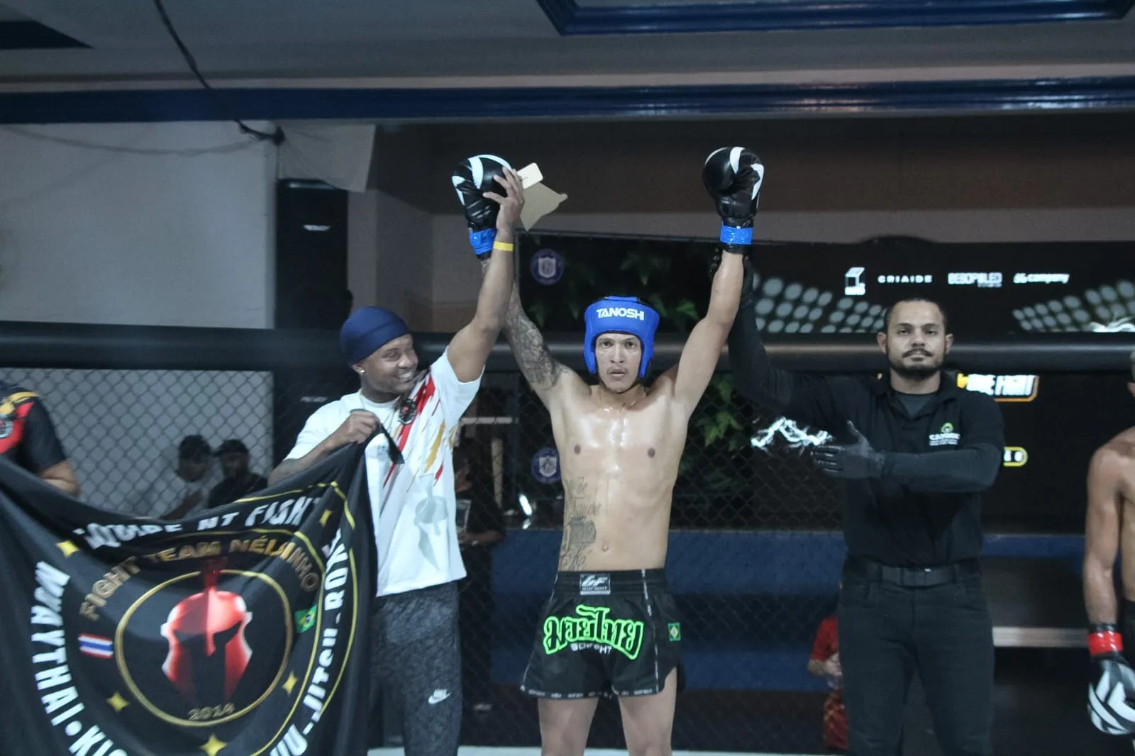Árbitro levantando o braço do atleta da NT Fight vitorioso no octógono