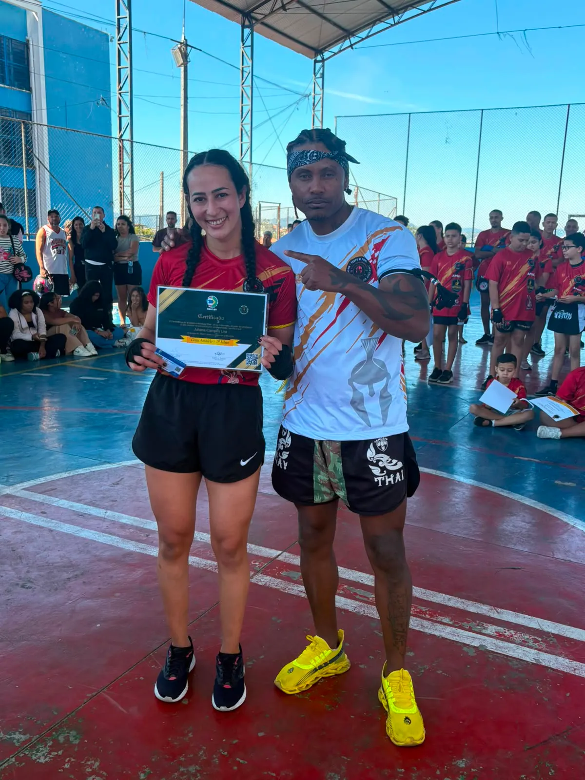 Aluna com o certificado de graduação, na quadra da cerimônia