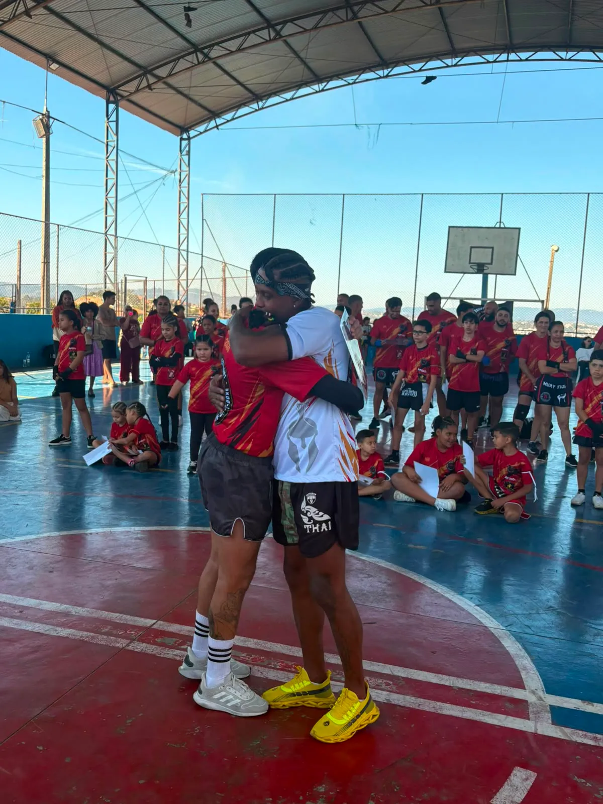 Aluno da Equipe NT Fight com o certificado de graduação ao lado do Prof. Nélsinho, na cerimônia de julho de 2026