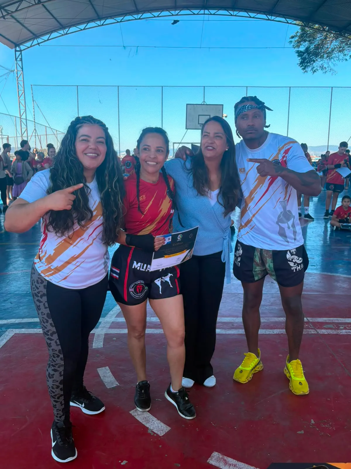 Aluno da Equipe NT Fight com o certificado de graduação ao lado do Prof. Nélsinho, na cerimônia de julho de 2026
