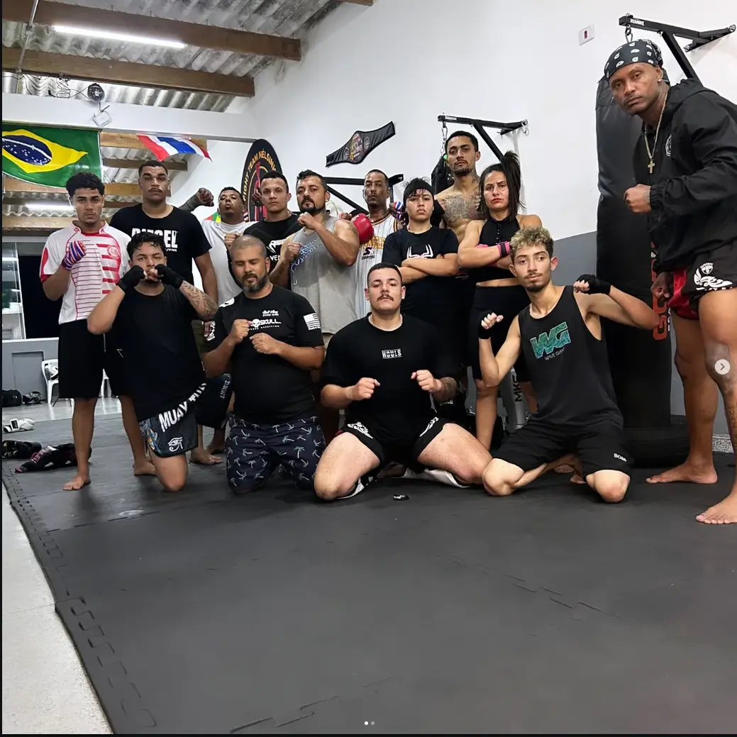 Turma de adultos da Equipe NT Fight posando em guarda no tatame do CT